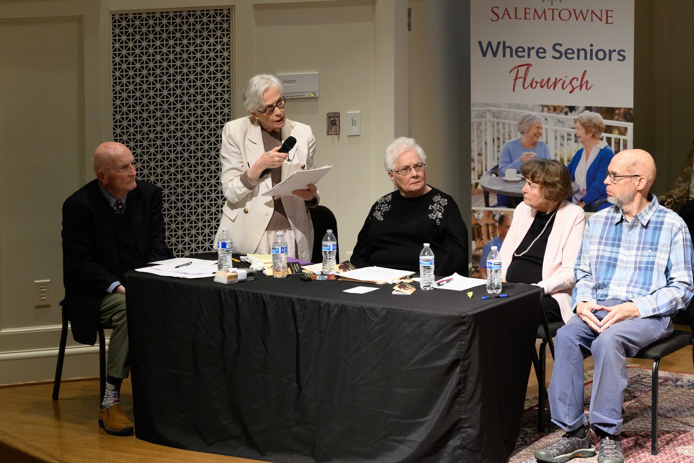 The Salemtowne Debate Society on stage: Fred Kahl, Perry Craven (standing at the microphone), Marianne Meyer, Barbara Gormsen, and Michael Boing.